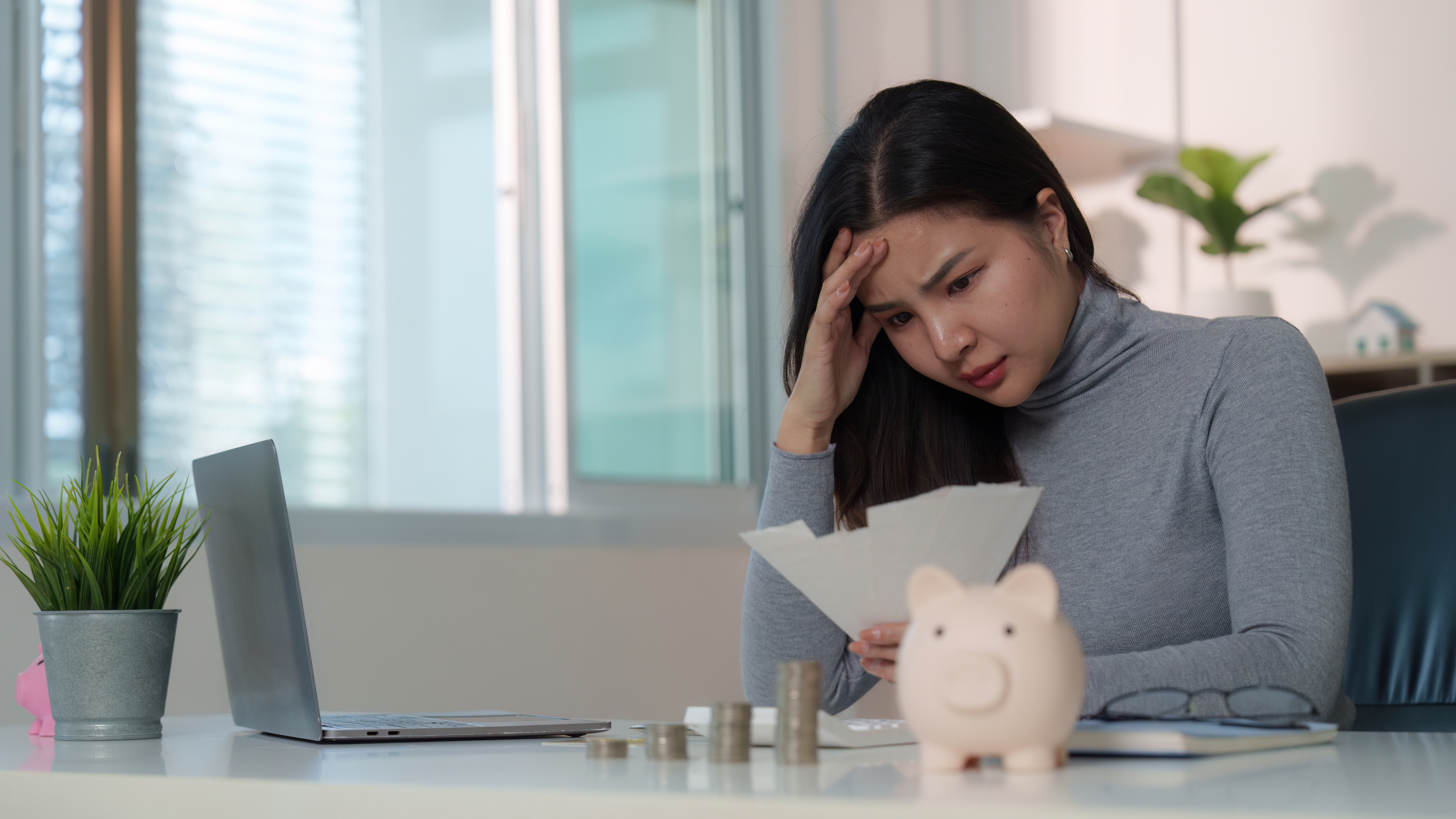 Mujer revisando facturas y presión financiera en el trabajo.