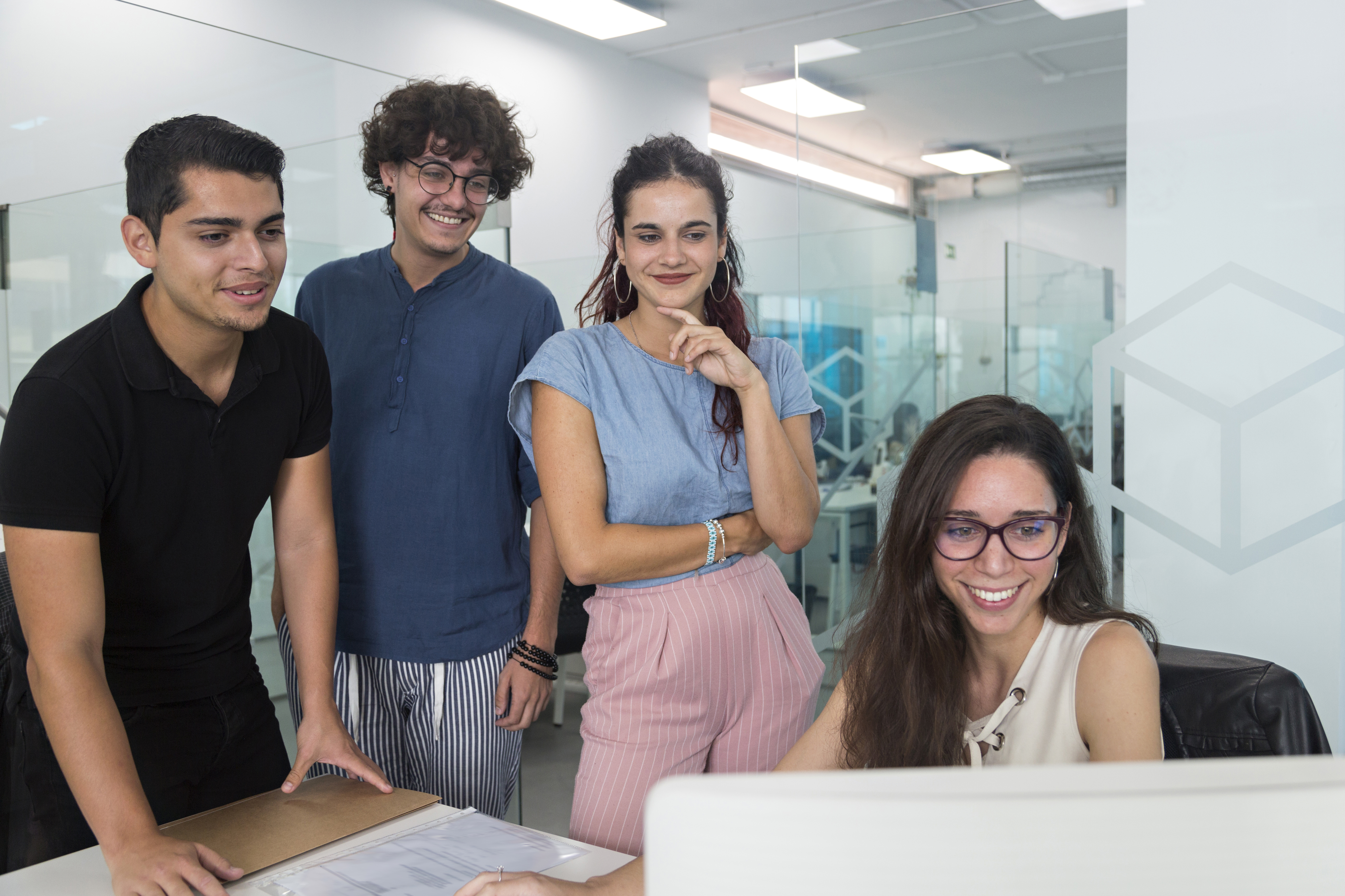 Equipo colaborando en proyecto en oficina moderna.